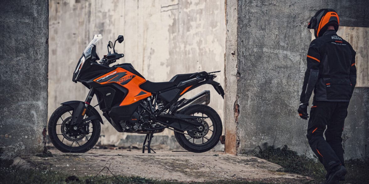 A picture of a KTM adventure bike with the rider walking towards the bike