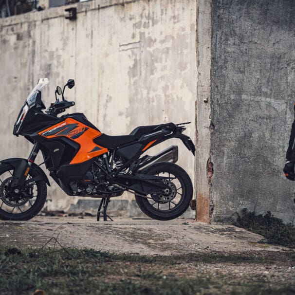 A picture of a KTM adventure bike with the rider walking towards the bike