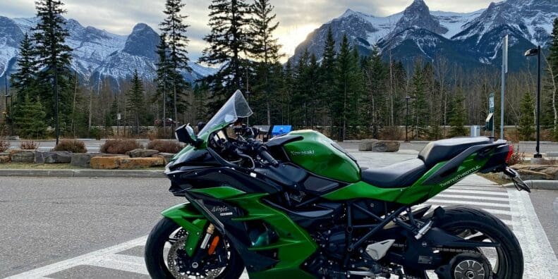 A view of a Kawasaki Ninja H2SX SE with mountains in the background