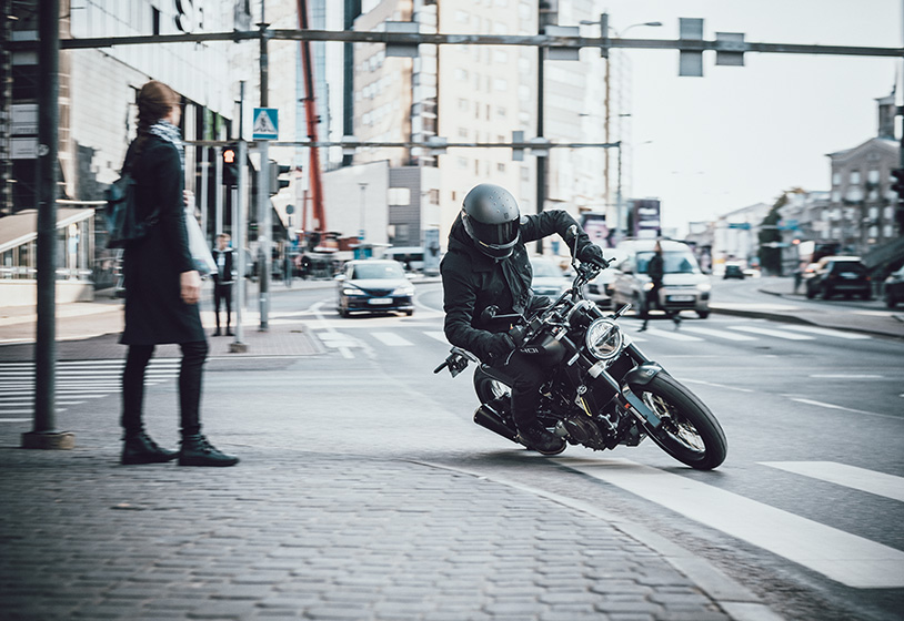 A view of a rider on the new 2021 Husqvarna Svartpilen 401, cornering an intersection in town.