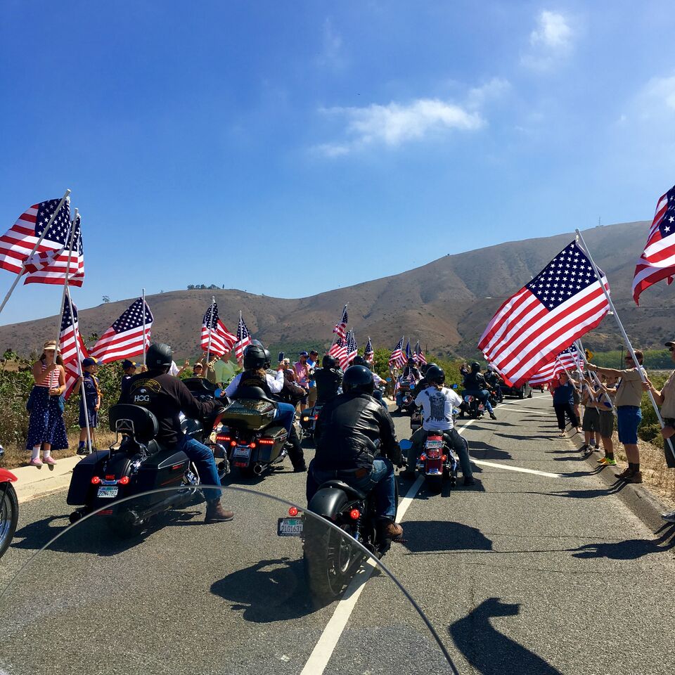 A view of civilians waving their flags in commemoration of lives lost during the 9/11 ride