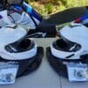 A view of two Outrush R Modular Helmets, in front of a BMW Motorcycle