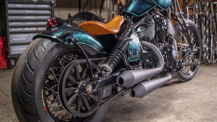 a rear 3/4 view of the custom motorcycle built by Indian Larry, Paul Cox, and Keino Sasaki