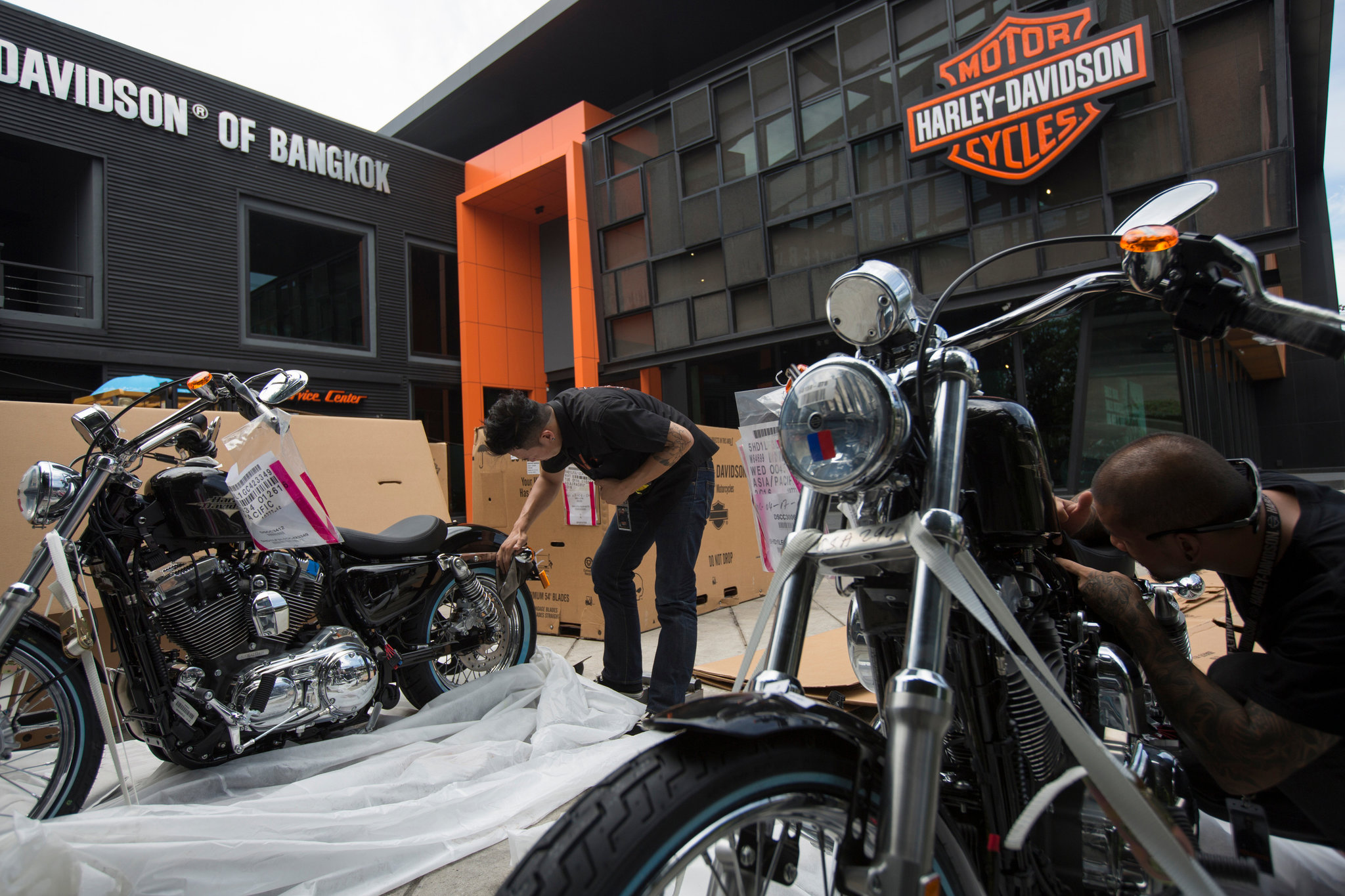 A view of H-D Dealership workers unwrapping new Harley Davidson bikes