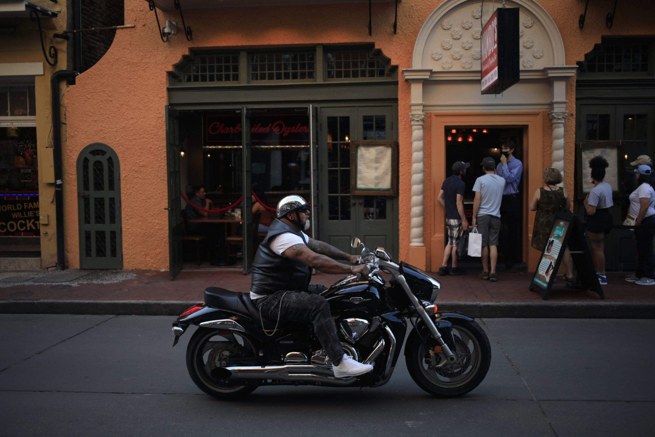 A person riding a motorcycle passes in front of customers standing in line to enter a restaurant on Bourbon Street in the French Quarter neighborhood in New Orleans, Louisiana, U.S., on Tuesday, April 20, 2021. Langer Research is releasing consumer comfort figures on April 22. Photographer: Luke Sharrett/Bloomberg