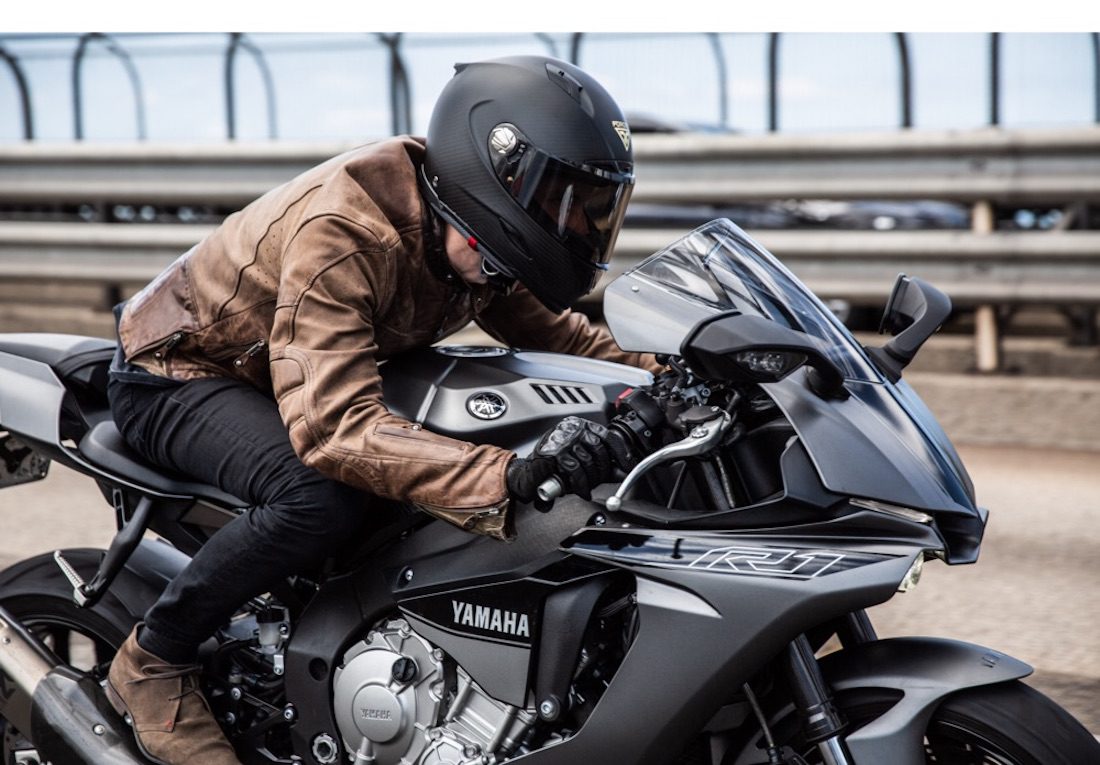 A side view of a rider positioned on a Yamaha R1 motorcycle