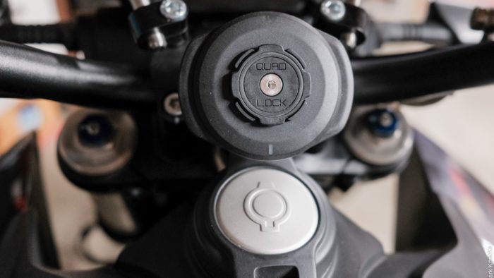 Closeup of the Quad Lock phone mount on the motorcycle handlebar