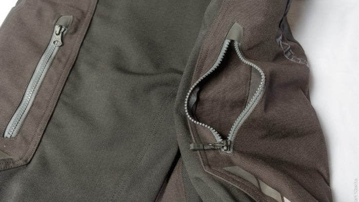 Closeup showing open upper zippered thigh pockets Closeup showing open upper zippered thigh pockets