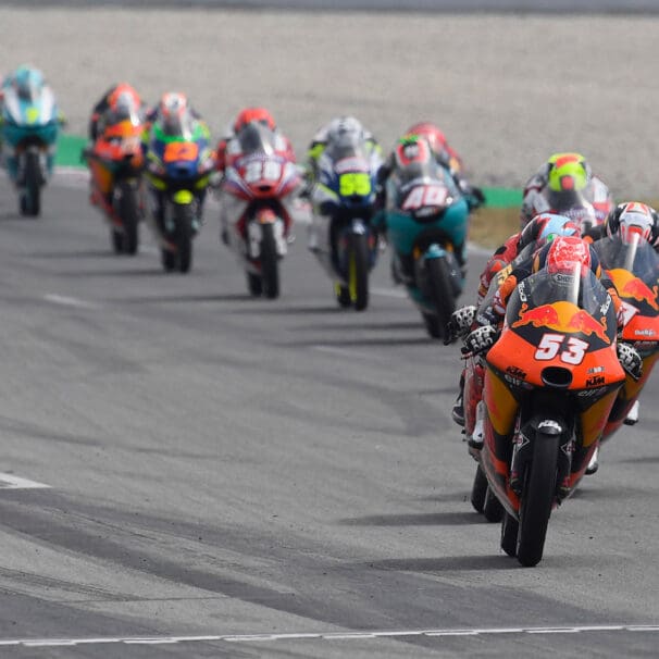 a lineup of Moto3 machines on a sharp turn.