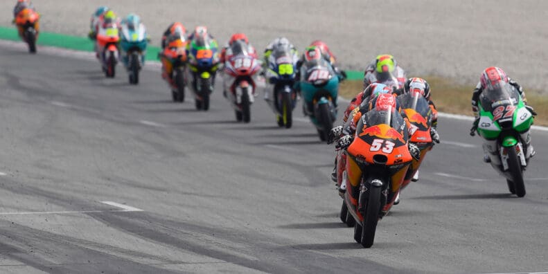 a lineup of Moto3 machines on a sharp turn.