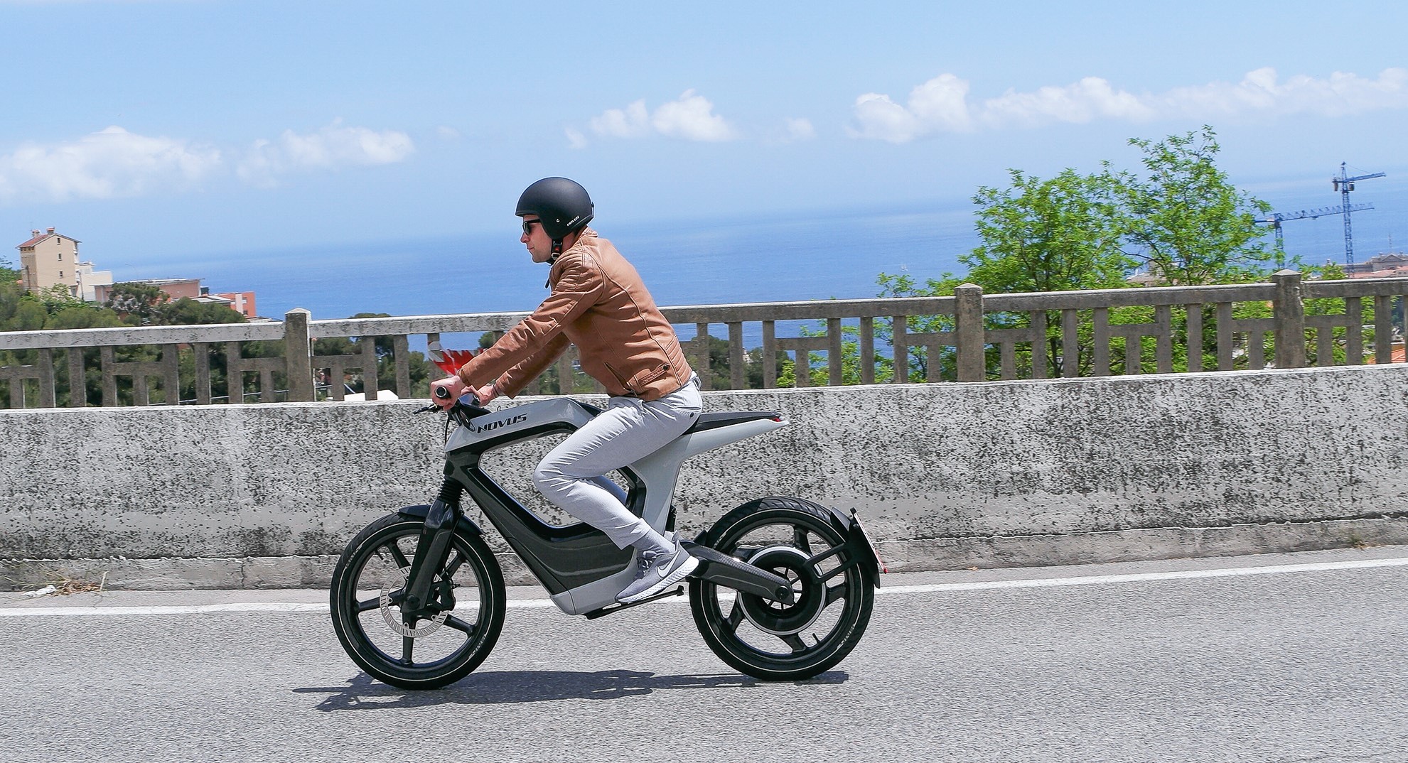 A side view of the Novus One with a rider trying out the bike on a bridge