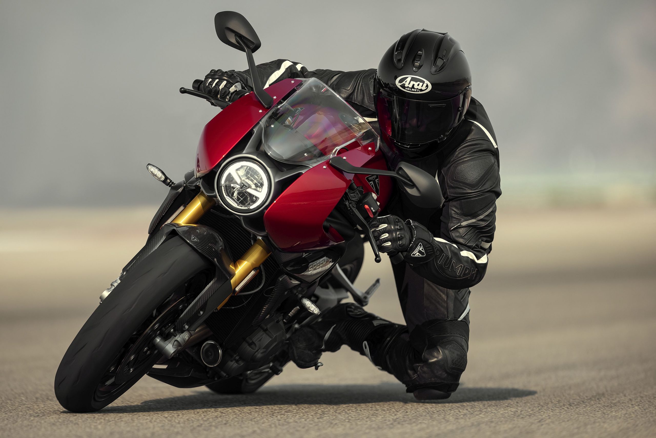 A front view of a rider leaning into the twisties with the 2022 Triumph Speed Triple 1200 RR