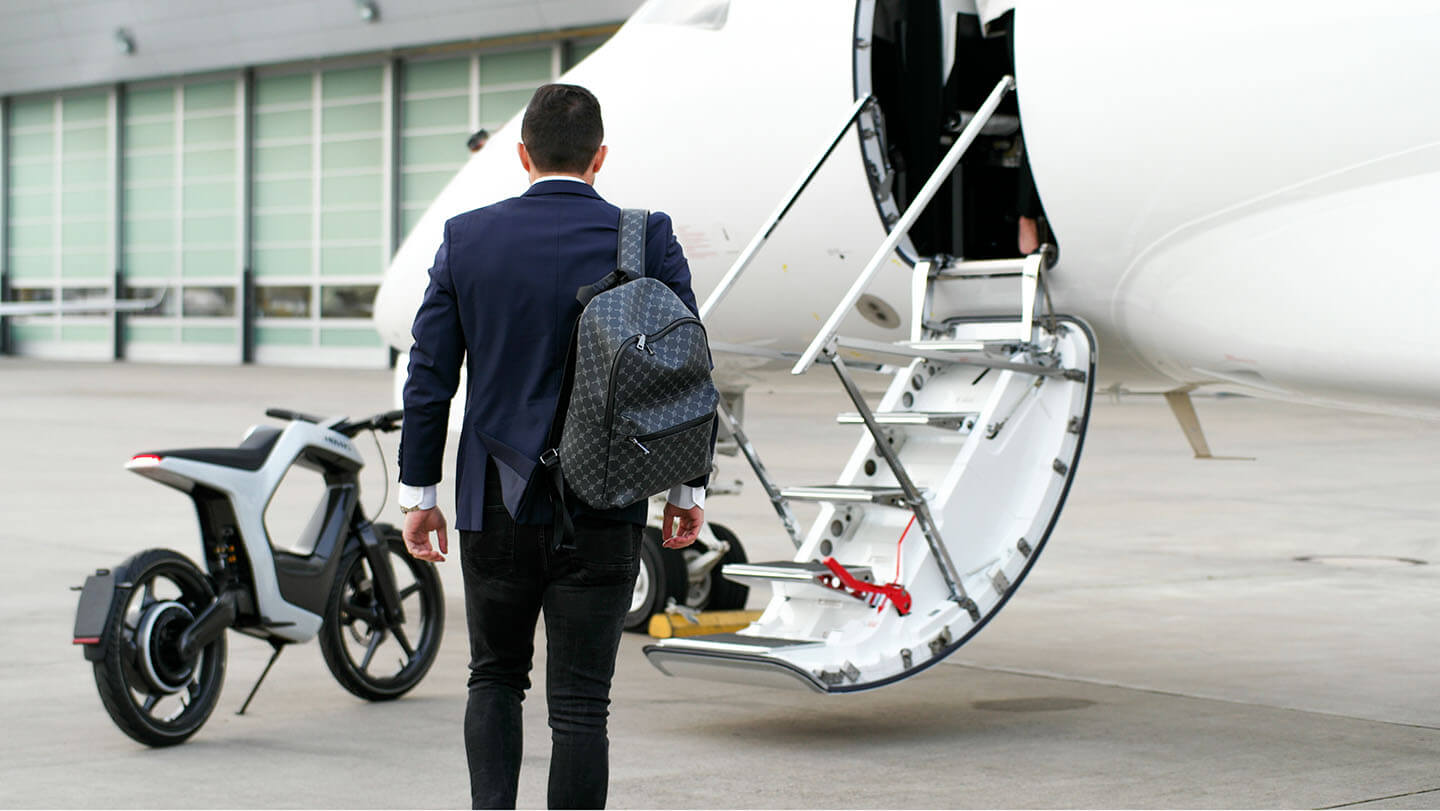 A side view of the Novus One with a model headed for his private jet