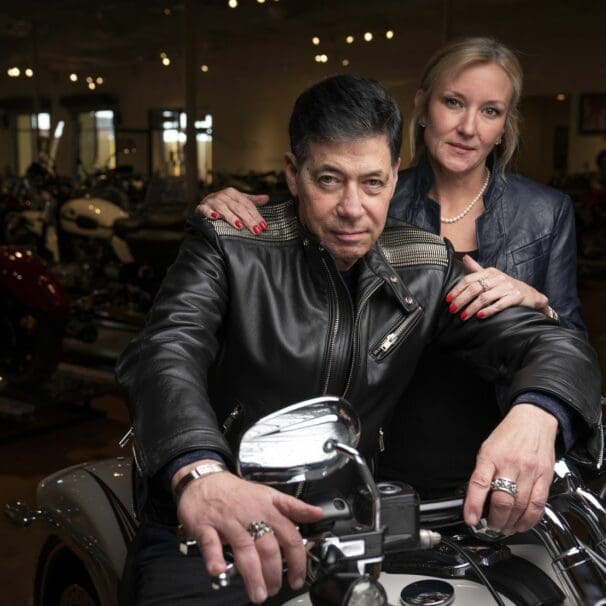 Robert Haas and partner as he sits on one of the motorcycles in his (Haas) Moto Museum