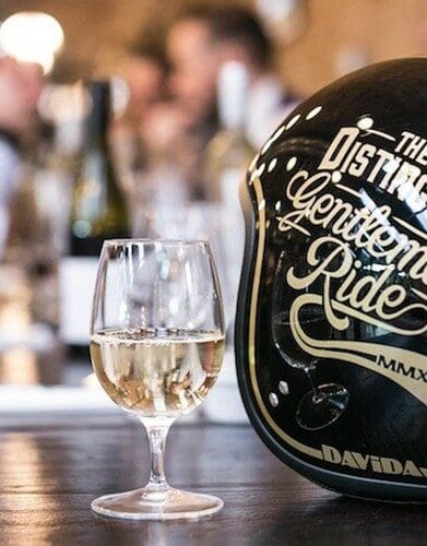 A view of a Distinguished Gentleman's Ride helmet with a glass of champagne