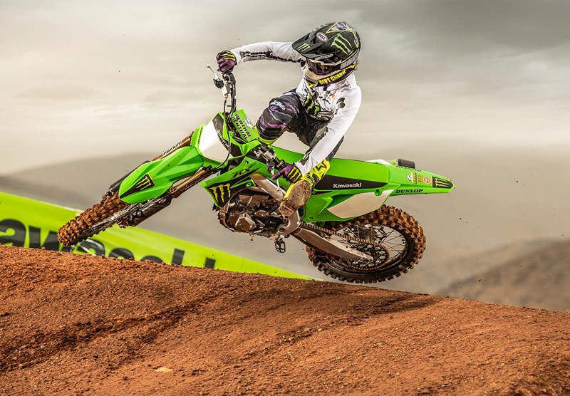 A side profile of a rider trying out the new 2022 Kawasaki KX450SR edition on a track