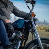 A reviewer trying out the Rev'it Echo Gloves in a glamour shot, riding a 1995 Harley Davidson and featuring a 883 Sportster Hugger and Joe Rocket Jacket.