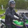Man wearing the Richa Airstorm WP Jacket while sitting on green Kawasaki motorcycle