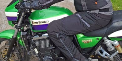 Rider wearing Richa Softshell WP Pants on green Kawasaki motorcycle