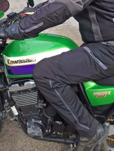 Rider wearing Richa Softshell WP Pants on green Kawasaki motorcycle