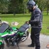 Rider wearing Richa Softshell WP Pants standing next to Kawasaki motorcycle
