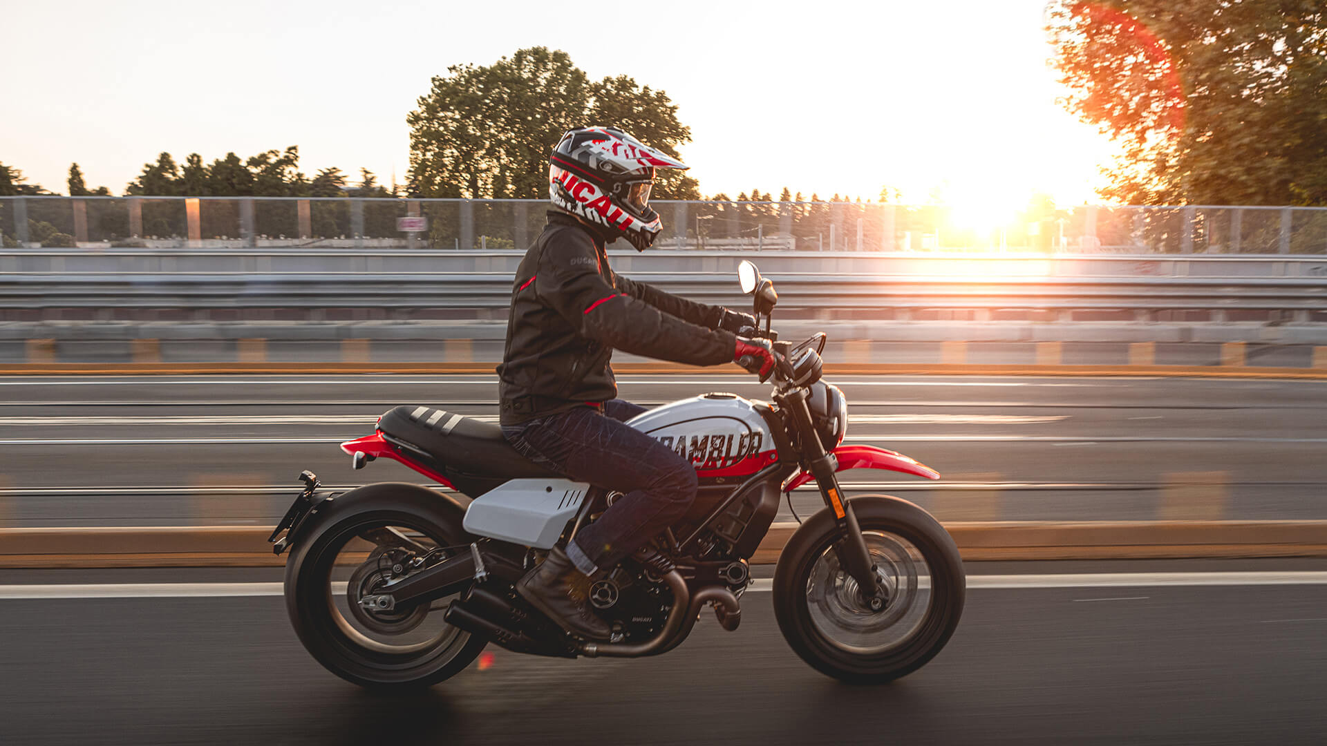 A side view of a model trying out the new Scrambler Ducati Urban Motorcycle courtesy of Ducati's World Premiere