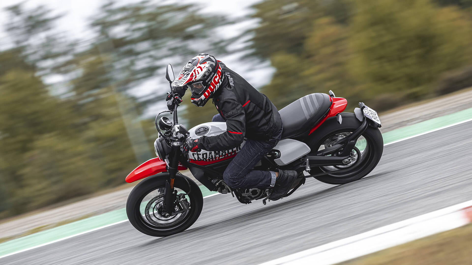 A side view of a model trying out the new Scrambler Ducati Urban Motorcycle courtesy of Ducati's World Premiere