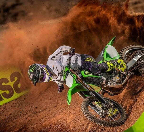 A side profile of a rider trying out the new 2022 Kawasaki KX450SR edition on a track