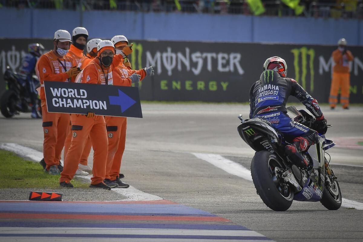 A view of workers prompting MotoGP's Championship racer to turn right