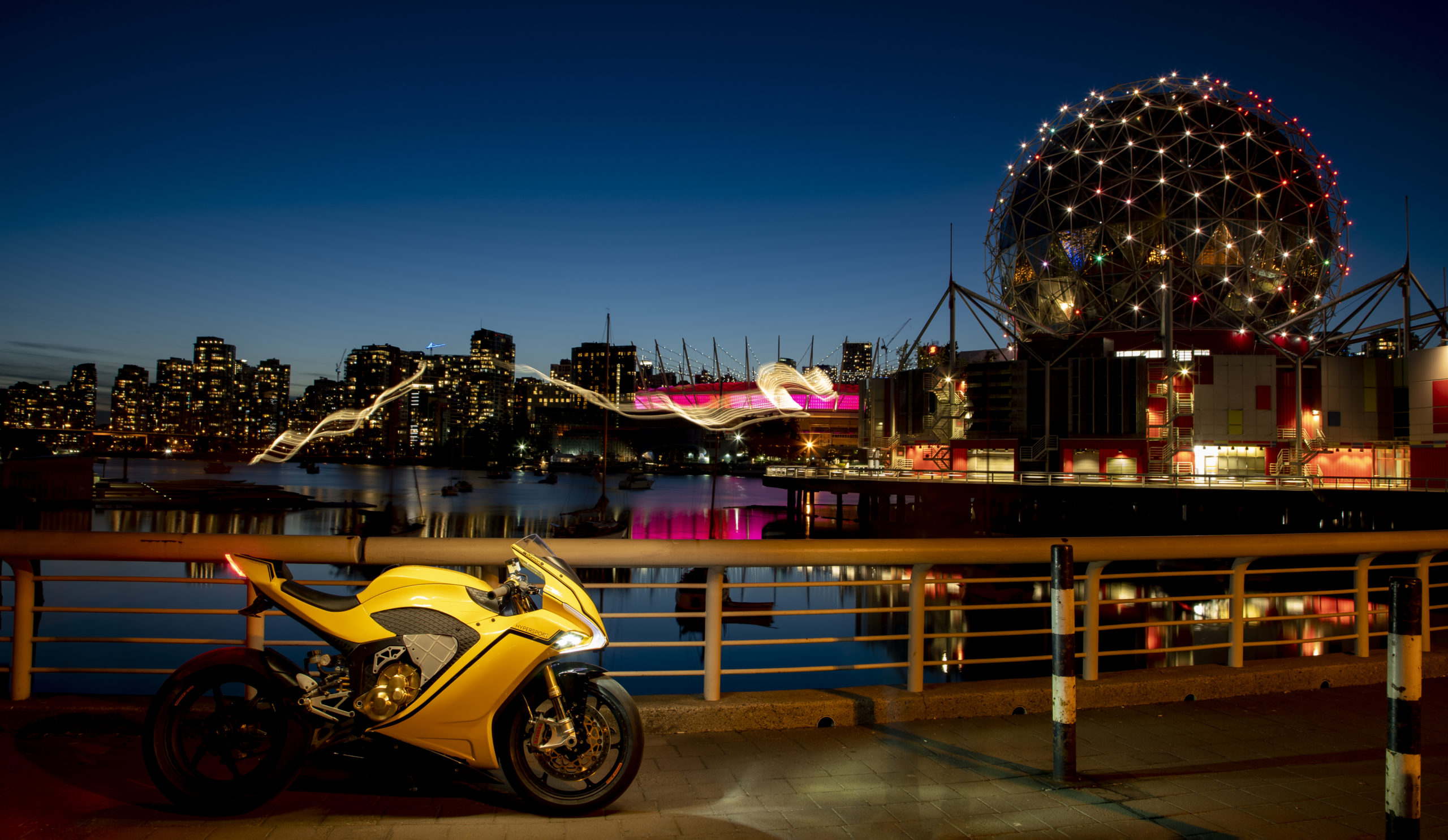 A side view of a Damon Hypersport in front of a night landscape scene