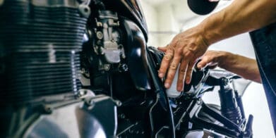Mechanic repairing customized motorcycle in the workshop