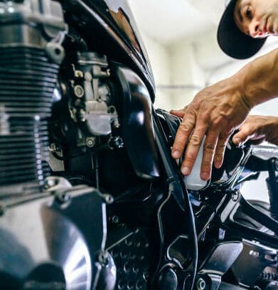 Mechanic repairing customized motorcycle in the workshop