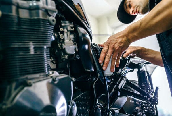 Mechanic repairing customized motorcycle in the workshop