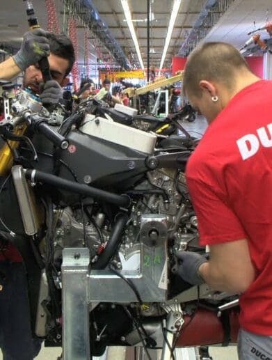 A worker toiling away at a Ducati bike in the creation process