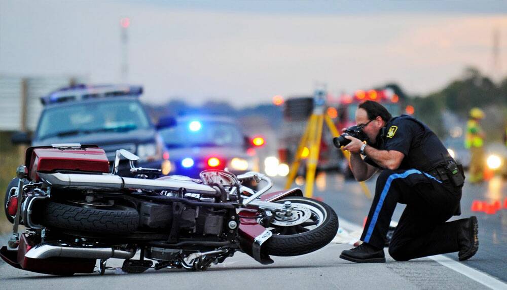 Officer taking photos of a motorcycle accident scene