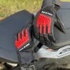 REV'IT Sand 4 Gloves in black and red lying on seat of motorcycle