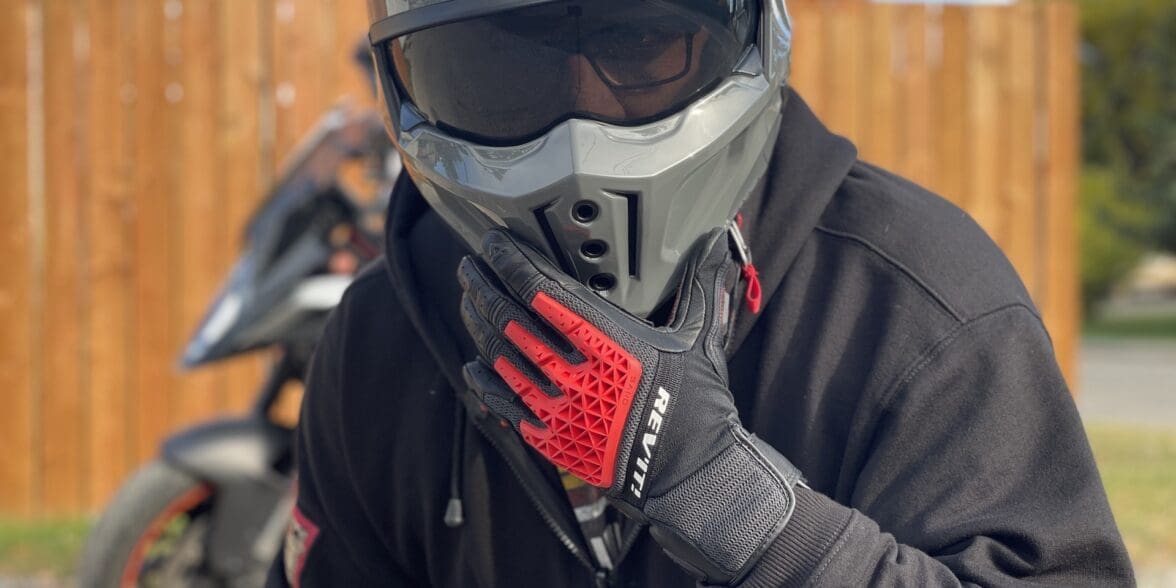 Rider wearing REV'IT Sand 4 Gloves in black and red with Scorpion Covert X helmet