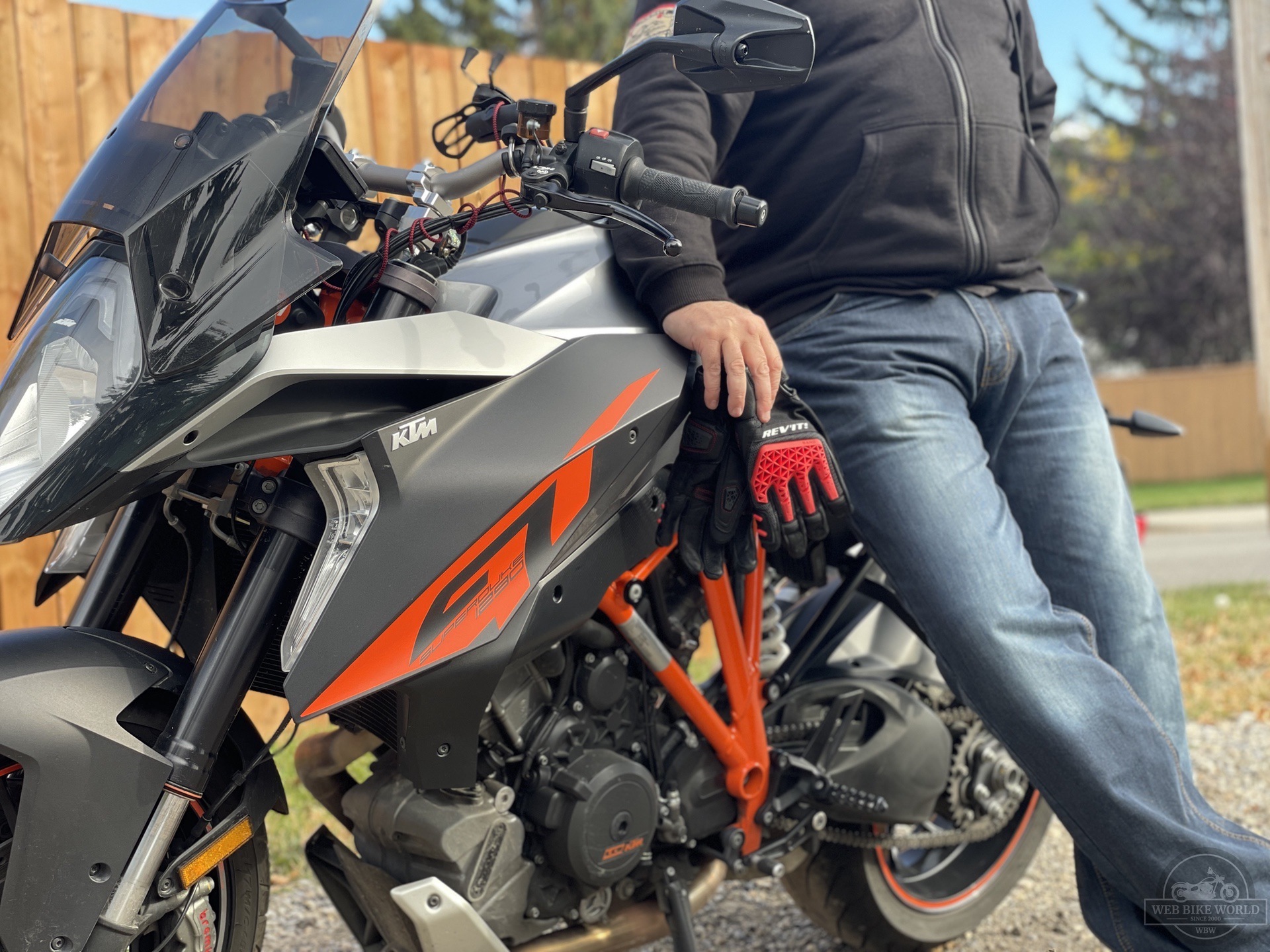 Rider holding Sand 4 Gloves while leaning against bike Rider holding Sand 4 Gloves while leaning against bike