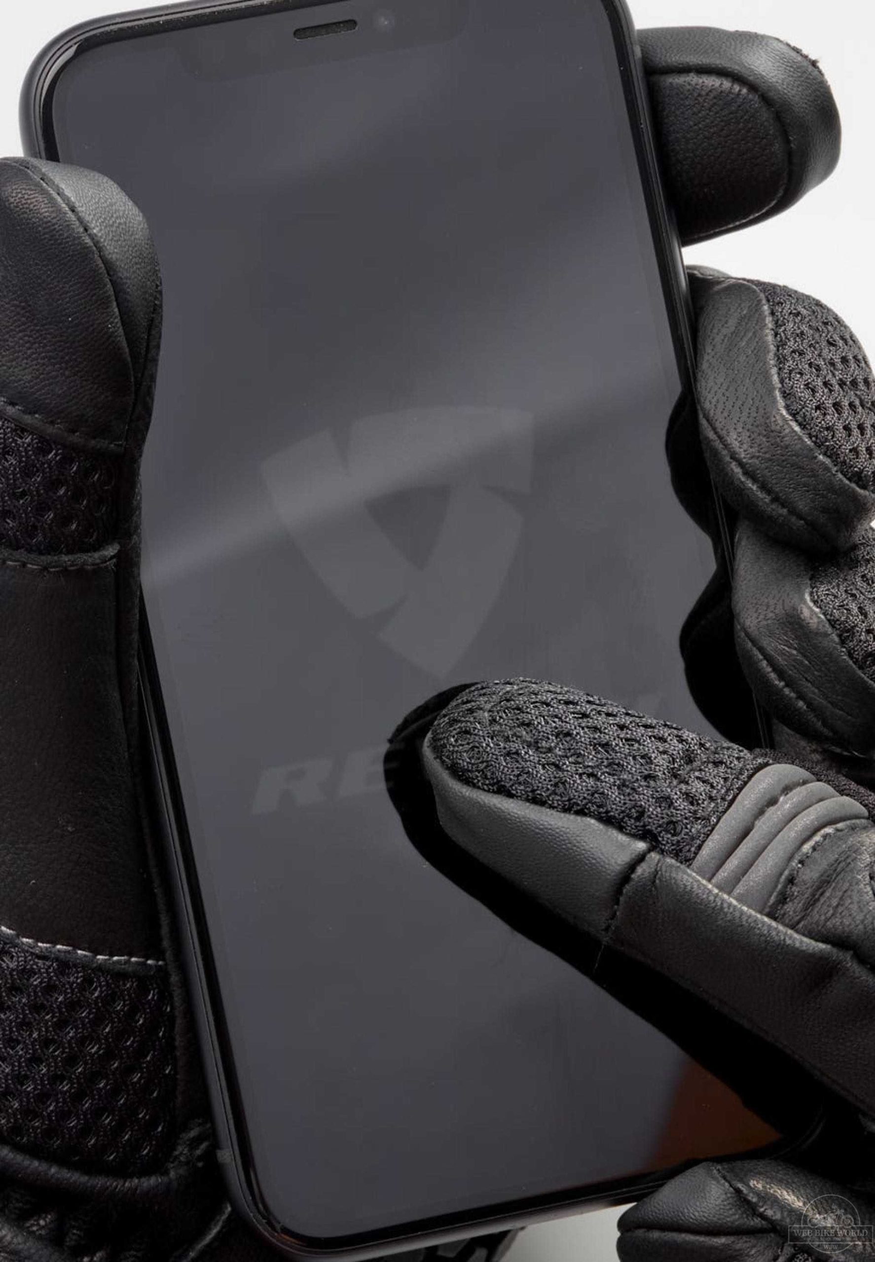 Close-up of Connect fingertip on REV'IT Sand 4 Gloves next to smartphone screen Close-up of Connect fingertip on REV'IT Sand 4 Gloves next to smartphone screen