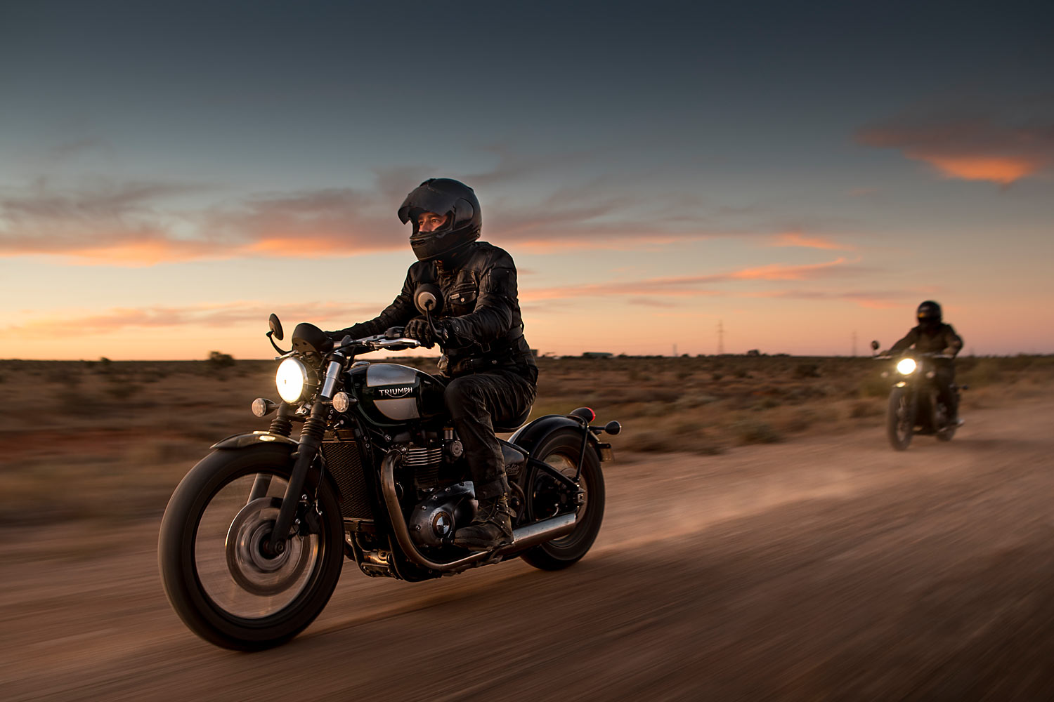 Two Triumph Bobber motorcycles at dusk in Broken Hill