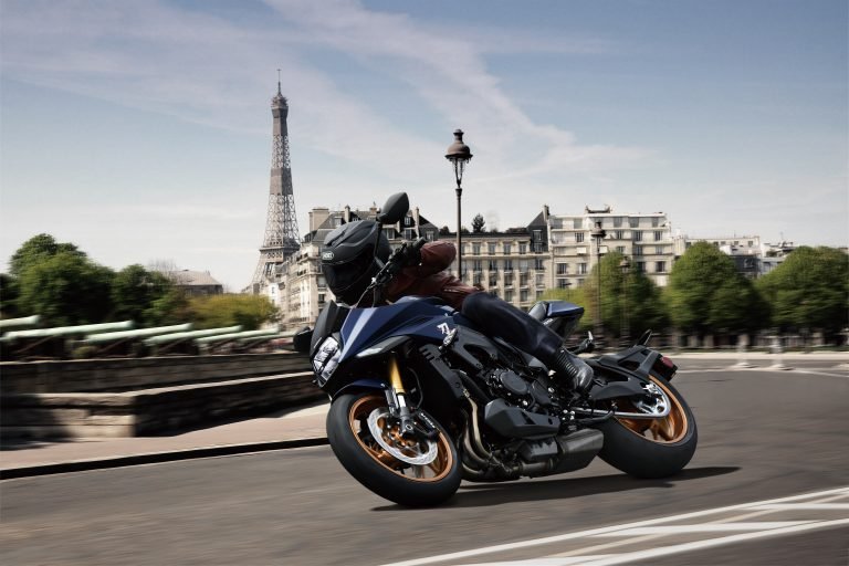 Suzuki Katana 2022: side view staged with rider and colourful background Suzuki Katana 2022: side view staged with rider and colourful background