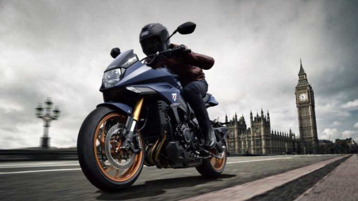 Suzuki Katana 2022: side view staged with rider and colourful background Suzuki Katana 2022: side view staged with rider and colourful background