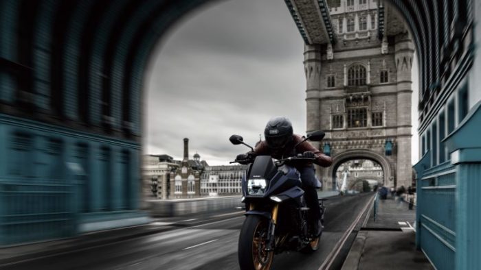 Suzuki Katana 2022: side view staged with rider and colourful background Suzuki Katana 2022: side view staged with rider and colourful background