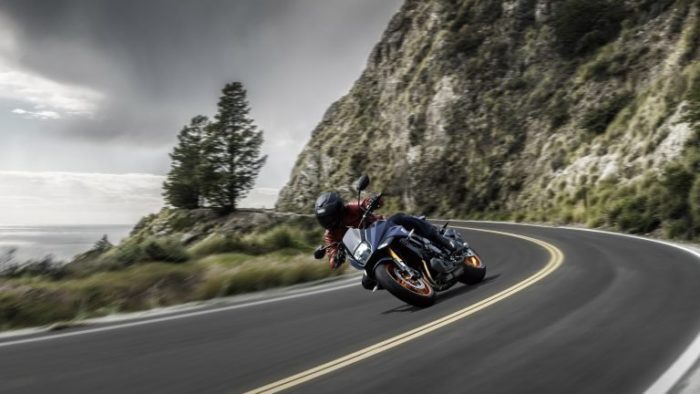 Suzuki Katana 2022: side view staged with rider and colourful background Suzuki Katana 2022: side view staged with rider and colourful background