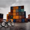 Shipping containers behind a beautiful motorcycle, symbolic of the shipping container inflation rates present in today's post