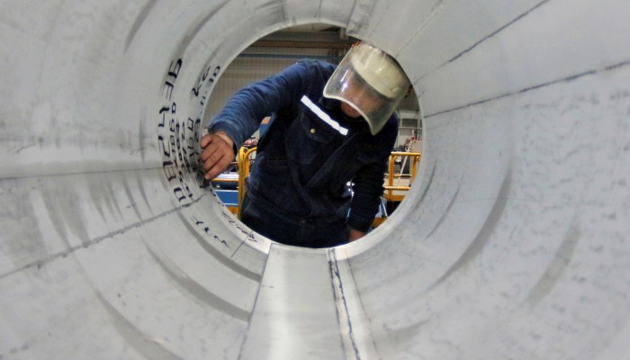 A view of a worker looking in a magnesium tube