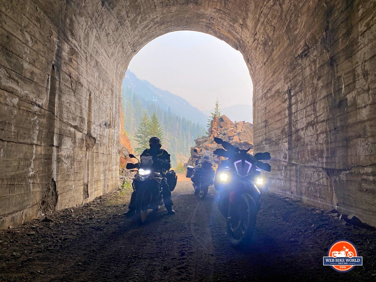 Three adventure motorcycles in old train tunnel in British Columbia in Canada