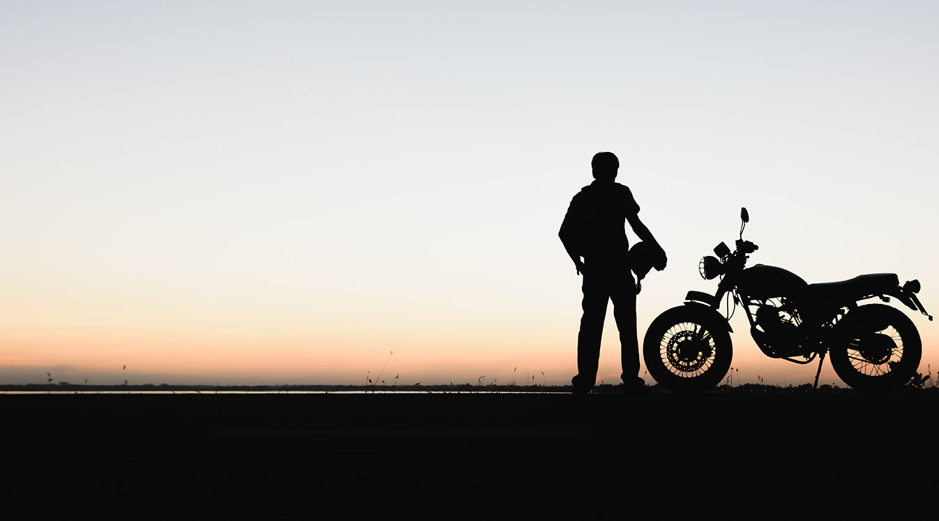 A silhouette of a motorcyclist enjoying the sunset