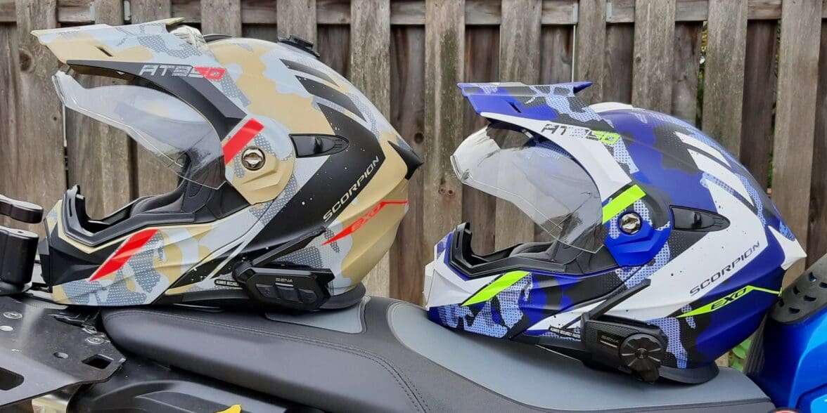 Sena SPIDER ST1 and RT1 mesh systems on two different helmets resting on motorcycle seat