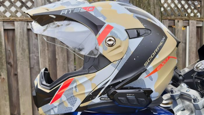 Sena SPIDER RT1 in Scorpion Exo helmet resting on blue bike Sena SPIDER RT1 in Scorpion Exo helmet resting on blue bike